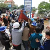  Các ngư dân chuyển thuyền đi biển xuống vùng lũ tại huyện Lệ Thủy hỗ trợ công tác cứu trợ đồng bào. (Ảnh: Thành Đạt/TTXVN)