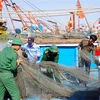 Bộ đội Biên phòng giúp ngư dân thu dọn ngư lưới cụ đảm bảo an toàn tài sản. (Ảnh: TTXVN phát)