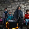Người dân Palestine sưởi ấm tại trại tị nạn ở thành phố Khan Younis, Dải Gaza ngày 26/11/2020. (Ảnh: THX/TTXVN)
