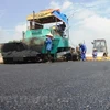 Nhà thầu tiến hành công tác thảm mặt đường, bảo trì đường bộ bị hư hỏng. (Ảnh: Vietnam+)