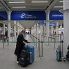 Hành khách đeo khẩu trang phòng lây nhiễm COVID-19 tại nhà ga quốc tế ở London, Anh, ngày 20/12/2020. (Ảnh: AFP/TTXVN)