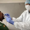  Nhân viên y tế lấy mẫu dịch xét nghiệm COVID-19 cho người dân tại Richmond, Johannesburg, Nam Phi, ngày 18/12/2020. (Ảnh: AFP/TTXVN)