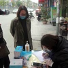 Người dân khai báo y tế trước khi vào chợ ở thành phố Hạ Long. (Ảnh: Đức Hiếu/TTXVN)