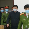Cảnh sát dẫn giải bị cáo Đinh La Thăng, cựu Chủ tịch Hội đồng quản trị Tập đoàn Dầu khí Việt Nam (PVN) tại phiên tòa ngày 22/1. (Ảnh: Doãn Tấn/TTXVN)