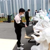 Công nhân Công ty Best Pacific thuộc Khu công nghiệp Lương Điền-Cẩm Điền, huyện Cẩm Giàng làm thủ tục trước khi lấy mẫu xét nghiệm. (Ảnh: Mạnh Tú/TTXVN)