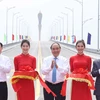 Thủ tướng Nguyễn Xuân Phúc và các đại biểu thực nghiện nghi thức cắt băng thông xe cầu Cửa Hội bắc qua Sông Lam. (Ảnh: Thống Nhất/TTXVN)