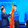 Ông Vương Đình Huệ - Ủy viên Bộ Chính trị, Bí thư Thành uỷ Hà Nội gắn Huân chương Lao động hạng Nhất lên cờ truyền thống của Thành đoàn Hà Nội. (Ảnh: Minh Đức/TTXVN)