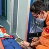 Lực lượng cứu nạn chăm sóc y tế cho nạn nhân trên tàu SAR 274. (Ảnh: TTXVN phát)
