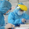 Các nhân viên y tế làm xét nghiệm SARS-CoV-2. (Ảnh: Văn Dũng/TTXVN)