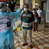 Kiểm tra thân nhiệt phòng lây nhiễm COVID-19 tại Campuchia. (Ảnh: AFP/TTXVN)