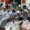 Các tình nguyện viên chia thực phẩm chuẩn bị cho người dân tại xã Mão Điền, huyện Thuận Thành, tỉnh Bắc Ninh. (Ảnh: Thanh Thương/TTXVN)