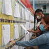 Giáo dân ở xã Gia Tân 1, huyện Thống Nhất, tỉnh Đồng Nai xem xét danh sách cử tri. (Ảnh: Công Phong/TTXVN)
