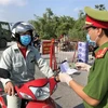 Lực lượng công an tại chốt kiểm dịch cầu Hồ, huyện Thuận Thành kiểm tra giấy tờ của người dân. (Ảnh minh họa: Đinh Văn Nhiều/TTXVN)