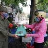 Phụ nữ phường Vũ Ninh, thành phố Bắc Ninh trao các suất cơm tình nguyện cho các tình nguyện viên chốt tại chốt kiểm soát dịch COVID-19 tại địa bàn phường Vũ Ninh, thành phố Bắc Ninh. (Ảnh: Thanh Thương/TTXVN)