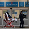 Nhân viên y tế chuyển bệnh nhân COVID-19 vào một bệnh viện ở New York, Mỹ. (Ảnh: AFP/TTXVN)
