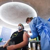 Nhân viên y tế tiêm vaccine phòng COVID-19 cho người dân tại Cologne, Đức. (Ảnh: AFP/TTXVN)