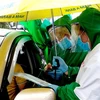  Lực lượng tình nguyện viên kiểm tra giấy xét nghiệm SARS-CoV-2 xe vào địa phận thành phố Cần Thơ. (Ảnh: Thu Hiền/TTXVN)