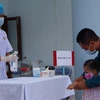 Lực lượng quân y của Trung tâm y tế thị trấn Trường Sa tiến hành kiểm tra sức khỏe và hướng dẫn phụ huynh cách chăm sóc, phòng chống dịch COVID-19. (Nguồn: TTXVN phát)