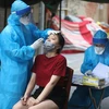 Nhân viên y tế lấy mẫu cho người dân trong khu vực phong tỏa tạm thời ở phố Hàng Mắm (phường Lý Thái Tổ) do liên quan đến trường hợp dương tính với SARS-CoV-2.(Ảnh: Minh Quyết/TTXVN)