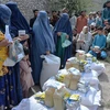 Phụ nữ nhận lương thực cứu trợ tại Jalalabad, Afghanistan, ngày 20/4/2021. (Ảnh: AFP/TTXVN)