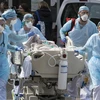 Nhân viên y tế chuyển bệnh nhân COVID-19 tại bệnh viện ở Mulhouse, miền Đông Pháp. (Ảnh: AFP/TTXVN)