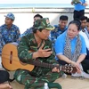 Thiếu tướng Nguyễn Hồng Sơn (ôm đàn) đang giới thiệu cho chiến sỹ, cán bộ trên đảo Đá Thị về bài hát 'Phút lặng im trên biển' do ông sáng tác. (Ảnh: Sỹ Tuyên/TTXVN)