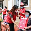 Phó Chủ tịch Hội Chữ thập Đỏ thành phố Hà Nội Đinh Thị Phức trao túi hàng gia đình tới người dân bị ảnh hưởng bởi dịch bệnh COVID-19 đang sống tại quận Thanh Xuân trong sáng 15/8. (Ảnh: Thanh Tùng/TTXVN)