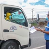 Lực lượng Thanh tra giao thông kiểm tra giấy tờ của một xe tải chờ hàng hóa vào thành phố Cần Thơ. (Ảnh: Thanh Liêm/TTXVN)
