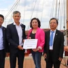 Đại sứ Nguyễn Minh Vũ (thứ 2 từ trái sang) tiếp nhận số tiền quyên góp của cộng đồng người Việt ở thành phố Rostock và vùng phụ cận. (Ảnh: Mạnh Hùng/TTXVN)