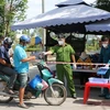 Lực lượng chức năng làm việc tại chốt kiểm soát phòng, chống dịch COVID-19 tại thị trấn Thạnh Hóa, huyện Thạnh Hóa. (Ảnh: Thanh Bình/TTXVN)
