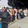 Người dân lên máy bay sơ tán khỏi Afghanistan tại Sân bay quốc tế ở Kabul. (Ảnh: Reuters/TTXVN)