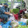 Cán bộ học viên Trường Sỹ quan thông tin phân loại rau xanh thành các đơn hàng cung ứng cho người dân xã Vĩnh Thọ, thành phố nơi Nha Trang. (Ảnh: Phan Sáu/TTXVN)