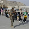 Binh sỹ Mỹ hỗ trợ người dân sơ tán khỏi Afghanistan, tại sân bay quốc tế Hamid Karzai ở Kabul ngày 18/8/2021. (Ảnh: AFP/TTXVN)