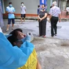 Lực lượng y tế quận Hoàng Mai tổ chức lấy mẫu xét nghiệm trong khu vực cách ly, sáng 28/8. (Ảnh: Hoàng Hiếu/TTXVN)