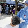 Nhân viên y tế lấy mẫu xét nghiệm cho người dân phường Thổ Quan, quận Đống Đa. (Ảnh: Trần Việt/TTXVN)