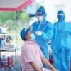 Đội thanh niên tình nguyện thuộc Tỉnh đoàn Bình Dương hỗ trợ ngành y tế lấy mẫu xét nghiệm tại 'vùng đỏ' của 15 phường trên địa bàn thành phố Thuận An, Dĩ An và thị xã Tân Uyên. (Ảnh: Chí Tưởng/TTXVN)