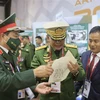 Tướng lĩnh quân đội Myanmar tìm hiểu về tranh trên giấy gió của Việt Nam. (Ảnh: Trần Hiếu/TTXVN)