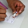 Nhân viên y tế điền thông tin vào giấy chứng nhận tiêm vaccine ngừa COVID-19 tại Los Angeles, California, Mỹ. (Ảnh: Getty Images/TTXVN)