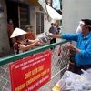 Liên đoàn Lao động quận Bình Thạnh trao quà cho người lao động trong khu vực phong tỏa. (Ảnh: Thanh Vũ/TTXVN)