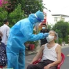 Cán bộ y tế tiến hành lấy mẫu gộp 3 người trong hộ gia đình để tầm soát cộng đồng diện rộng tại thành phố Nha Trang. (Ảnh: Phan Sáu/TTXVN)