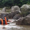 Lực lượng tìm kiếm nạn nhân bị nước cuốn trôi tại xã Đất Bằng (Krông Pa, Gia Lai). (Ảnh: TTXVN phát)