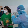 Người dân phường 'vùng xanh' Tương Bình Hiệp, thành phố Thủ Dầu Một, tỉnh Bình Dương tiêm vaccine phòng COVID-19. (Ảnh: Chí Tưởng/TTXVN)
