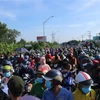 Hàng ngàn người dân chờ đợi qua chốt kiểm soát dịch trên Quốc lộ 1 (giáp ranh Long An-Tiền Giang) để về quê. (Ảnh: Bùi Giang/TTXVN)