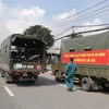 Lực lượng kiểm soát quân sự vận chuyển xe máy cho người dân lên xe ôtô chở về quê. (Ảnh: TTXVN phát)