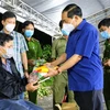 Thiếu tướng Nguyễn Văn Thuận, Giám đốc Công an thành phố Cần Thơ tặng quà hỗ trợ cho người dân về quê tại chốt kiểm soát ở quận Cái Răng tối 9/10. (Ảnh: Thanh Liêm/TTXVN)