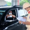 Cảnh sát giao thông kiểm tra giấy tờ của người dân khi di chuyển qua chốt kiểm soát liên ngành phòng, chống dịch COVID-19 Dốc Xây, thị xã Bỉm Sơn. (Ảnh: Nguyễn Nam/TTXVN)