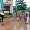 Phụ nữ tham gia dọn dẹp vệ sinh khắc phục hậu quả sau mưa lũ. (Ảnh: Võ Dung/TTXVN)