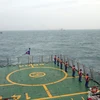 Cảnh sát biển hai nước Việt Nam và Trung Quốc thực hiện nghi thức chào xã giao trên biển. (Ảnh: TTXVN phát)