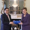 Thủ hiến Vùng Scotland Nicola Sturgeon tặng quà lưu niệm Thủ tướng Phạm Minh Chính. (Ảnh: Dương Giang/TTXVN)