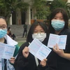 Học sinh Trường Tiểu học, Trung học cơ sở, Trung học phổ thông Văn Lang (Hạ Long) được cấp chứng nhận đã tiêm vaccine. (Ảnh: Thanh Vân/TTXVN)